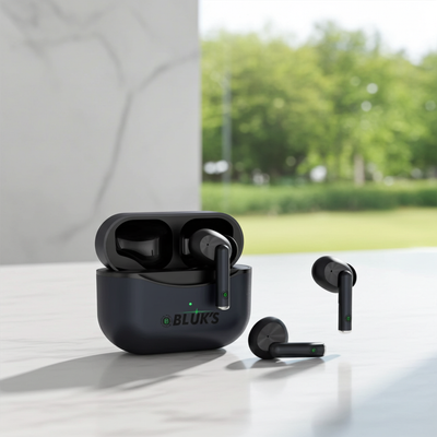 Black wireless earbuds with charging case on a reflective surface, blurred green outdoor background