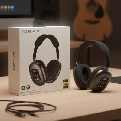 Black headphones with digital display on a wooden surface, next to their packaging box labeled 'AKZ Max700'.