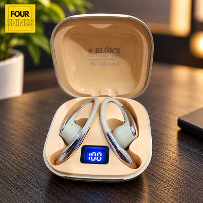 A pair of BLÜKS wireless earbuds resting inside an open beige charging case on a dark wooden table. The case has a small blue digital display showing '100' and the brand name 'BLÜKS' is printed inside the lid.