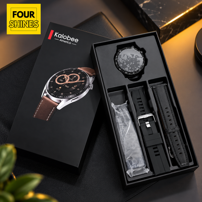 Kalobee smartwatch shown in an open black presentation box with a matching branded box beside it. The watch has a round black dial and a black strap, with a second black strap laid next to it.
