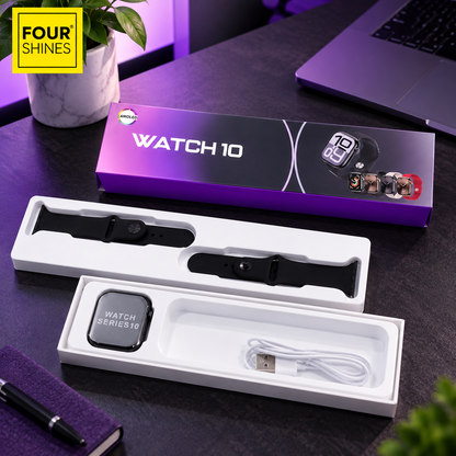 A boxed smartwatch product shown on a desk with the watch inside its retail box, an open tray containing a black band and a black smartwatch, and a white charging cable. The scene includes a laptop, plant, and purple ambient lighting.