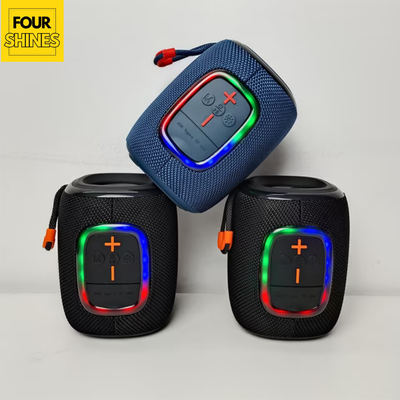 Three blue and black portable speakers with colorful LED lights on a light gray background, branded 'Four Shines'.
