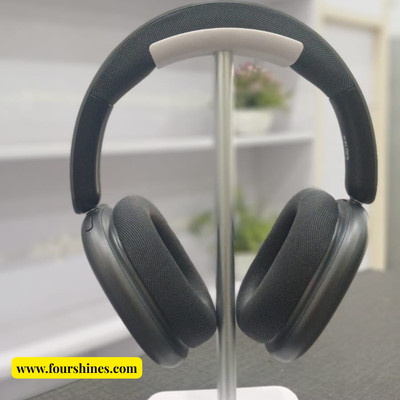Black over-ear headphones on a stand with a blurred indoor background