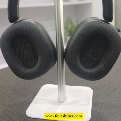 Black headphones on a white stand with 'www.fourshines.com' branding.