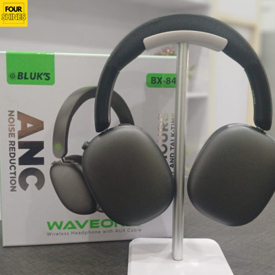 Black wireless headphones on a stand with a branded box in the background