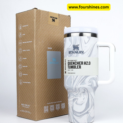 Stanley Quencher H2.0 tumbler with marble design next to its packaging box on a white background.
