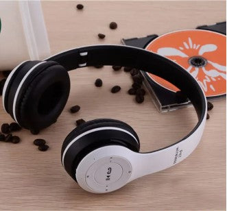 A pair of white and black P47 multifunctional noise-cancelling, microphone-enabled, foldable wireless Bluetooth stereo headphones displayed on a surface with coffee beans scattered around.