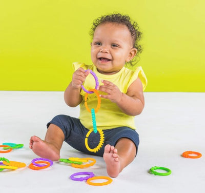 A set of colorful, adjustable rings designed for newborns and toddlers, displayed in an open gift box.