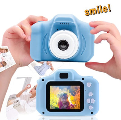 A child holding a blue digital camera with a 2.0 inch screen, displaying a smiling face on the screen.