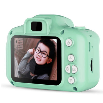 A child holding a blue digital camera with a 2.0 inch screen, displaying a smiling face on the screen.