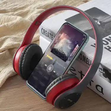 A pair of red P47 wireless Bluetooth headphones displayed next to its packaging box and a USB charging cable.