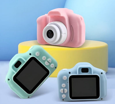 Two children's digital cameras, one pink and one blue, with 2.0 inch screens displayed against a yellow and blue background.