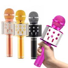 Four colorful handheld microphones with a hand holding one of them.