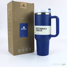 Blue travel mug with handle and pen, branded 'G chermerzo & Sommer', next to a matching box on a white background.