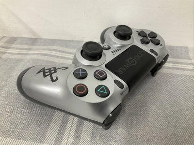 Silver gaming controller with logo on a textured surface